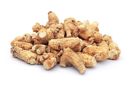 Getrocknete Ginseng-Wurzelstücke auf weißem Hintergrund.